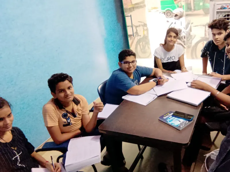 Students with notebooks around a study table